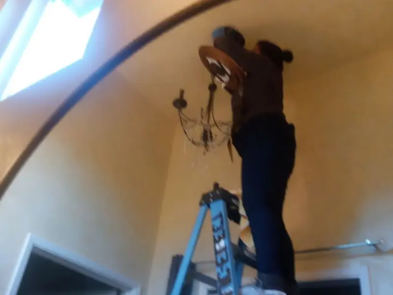 Electrician installing a chandelier in a Savannah residence